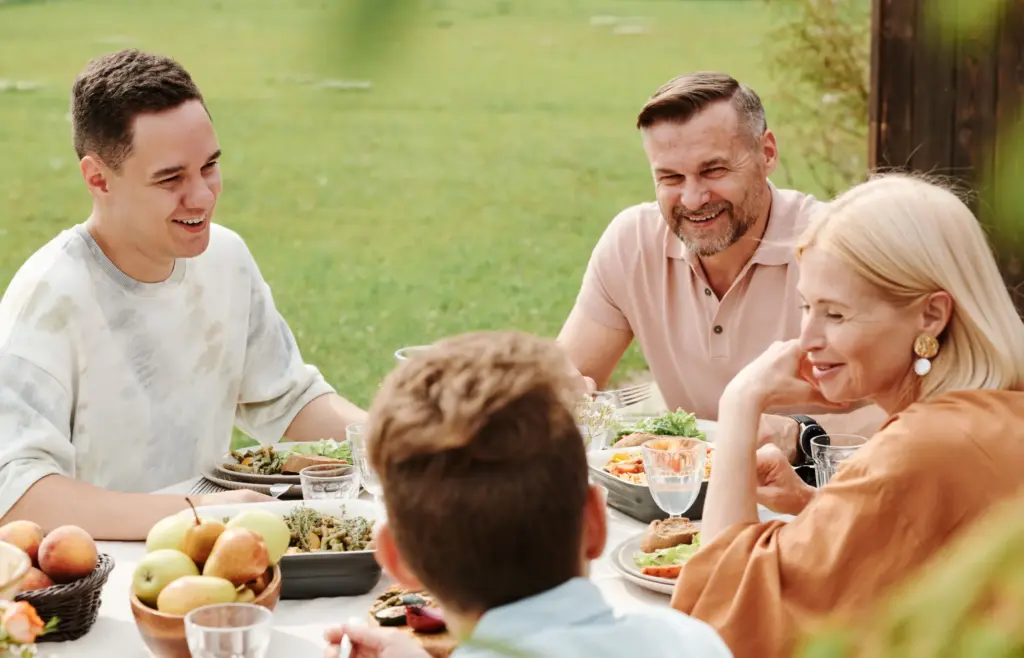 A Family Enjoying A Meal Outdoors